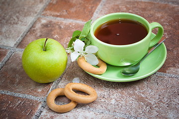 Image showing Cup of tea with an apple