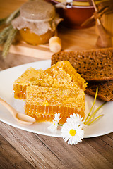 Image showing honeycomb with daisies on white plate 