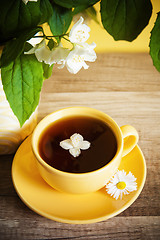 Image showing Cup of tea and a bouquet of blooming Jasmine