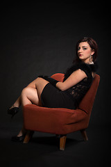 Image showing Young woman in retro clothing on old orange chair