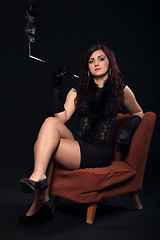 Image showing Young woman in retro clothing on old orange chair