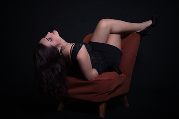 Image showing Young woman in retro clothing on old orange chair
