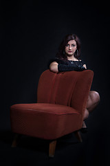 Image showing Young woman in retro clothing on old orange chair