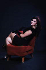 Image showing Young woman in retro clothing on old orange chair