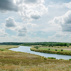 Image showing dramatic sky over green landscape with river