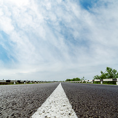 Image showing white line on asphalt road and clouds over it