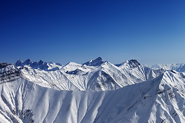 Image showing Snowy winter rocks in sun day, view from ski slope