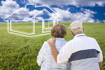 Image showing Senior Couple Standing in Grass Field Looking at Ghosted House