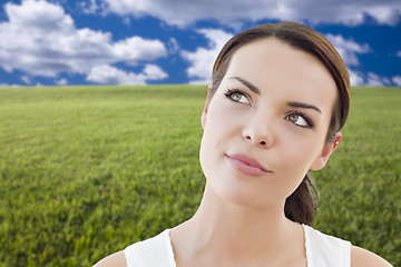 Image showing Contemplative Woman in Grass Field Looking Up and Over