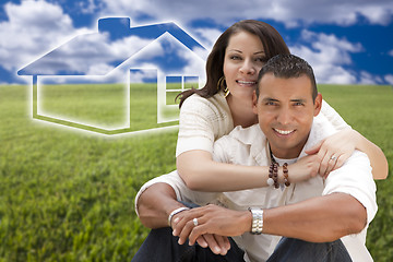 Image showing Hispanic Couple Sitting in Grass Field with Ghosted House Behind