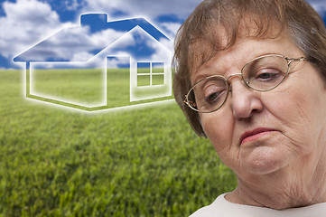 Image showing Melancholy Senior Woman with Grass Field and Ghosted House Behin