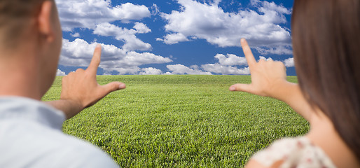 Image showing Couple Framing Hands Around Space in Grass Field