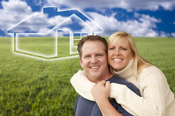 Image showing Happy Couple Hugging in Grass Field with Ghosted House Behind