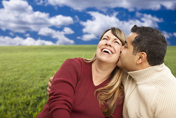 Image showing Happy Mixed Couple Sitting in Grass Field 