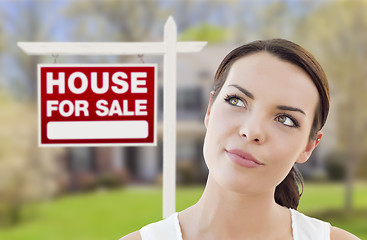 Image showing Thinking Woman In Front of House and For Sale Sign