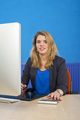 Image showing Young woman behind a computer