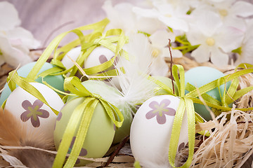 Image showing Colourful green Easter eggs in straw