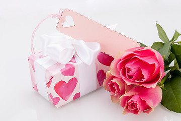 Image showing Gift box with an empty tag, next to three roses