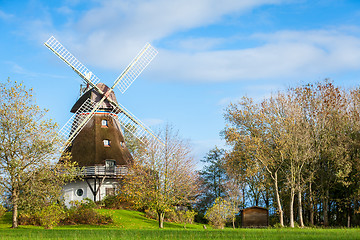 Image showing Traditional wooden windmill in a lush garden