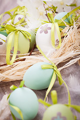 Image showing Colourful green Easter eggs in straw