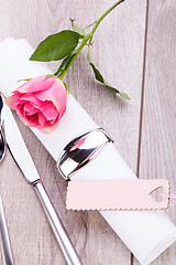 Image showing Table setting with a single pink rose