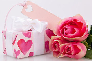 Image showing Gift box with an empty tag, next to three roses