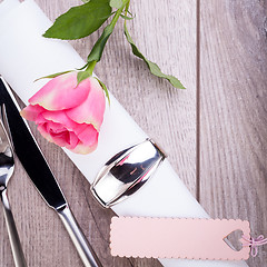 Image showing Table setting with a single pink rose