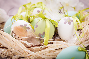 Image showing Colourful green Easter eggs in straw