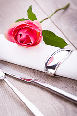 Image showing Table setting with a single pink rose