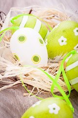 Image showing Colourful green Easter eggs in straw