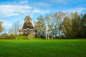 Image showing Traditional wooden windmill in a lush garden