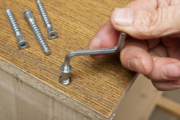 Image showing Tightening the screws by hand when assembling furniture