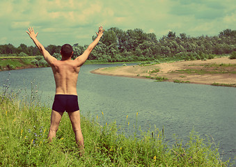 Image showing man with hands up near river - vintage retro style