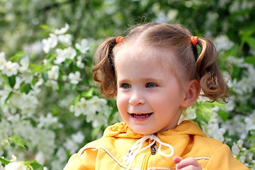 Image showing little girl near blossoming apple tree