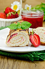 Image showing Roulade with a jar of jam and strawberries on a board