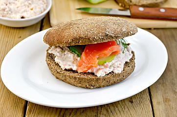 Image showing Sandwich with cream and salmon on a board with a knife