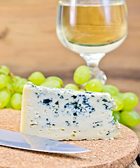 Image showing Cheese blue on board with wine and grapes