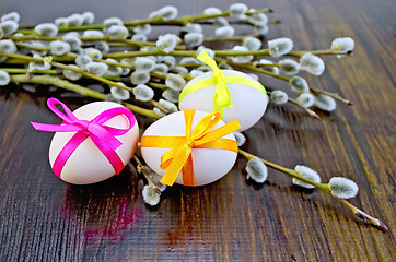 Image showing Easter eggs with ribbons and willow on the board