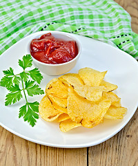 Image showing Chips with tomato sauce on a board