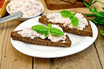 Image showing Sandwiches with cream of salmon with basil on board