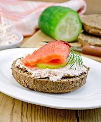 Image showing Sandwich with cream and salmon with cucumber on the board