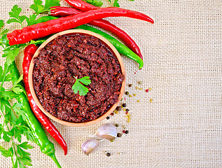 Image showing Adjika with hot pepper and parsley on burlap