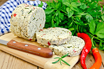 Image showing Cheese homemade with hot peppers on board with knife