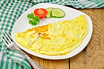 Image showing Omelet with vegetables and fork on a board