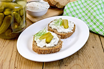 Image showing Sandwich with cream and pickles on a board