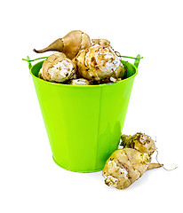 Image showing Jerusalem artichokes in a green bucket and on the table