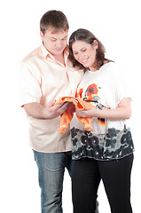 Image showing Expectant parents with baby clothes