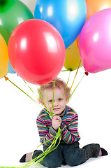 Image showing Little girl with multicolored air balloons sitting