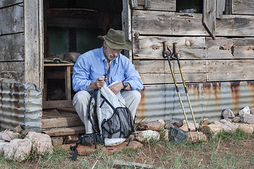 Image showing hiker and old mountain cabin