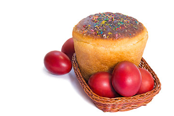 Image showing Red Easter eggs and Easter bread in a basket on a white backgrou